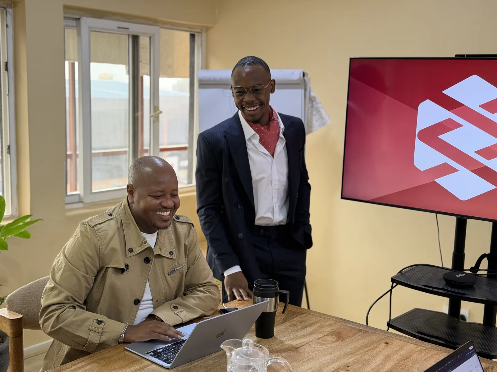 Two senior Data XL colleagues talking over a laptop in the Nairobi office