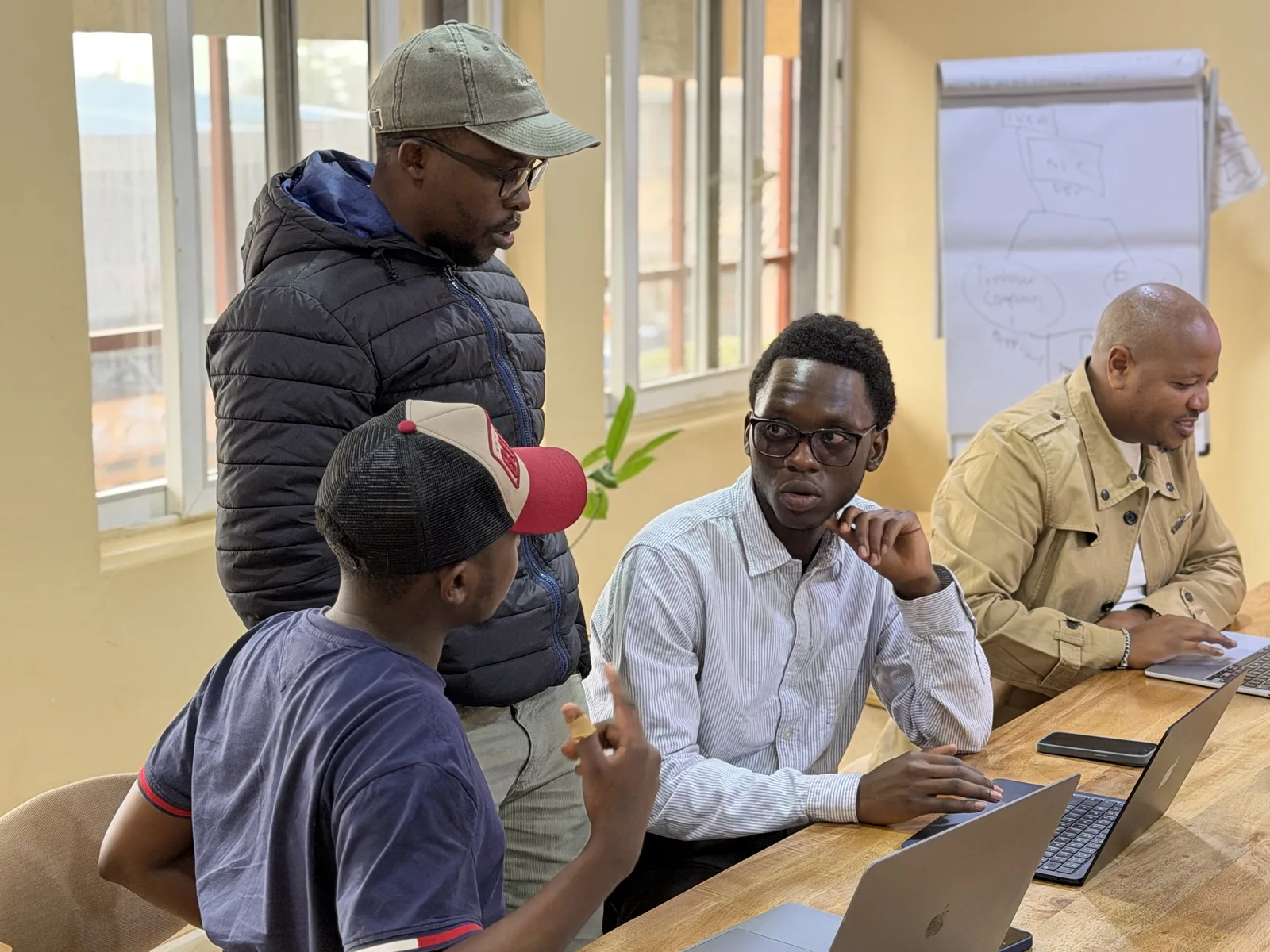 Four Data XL colleagues working through a problem together at the table in the Nairobi office