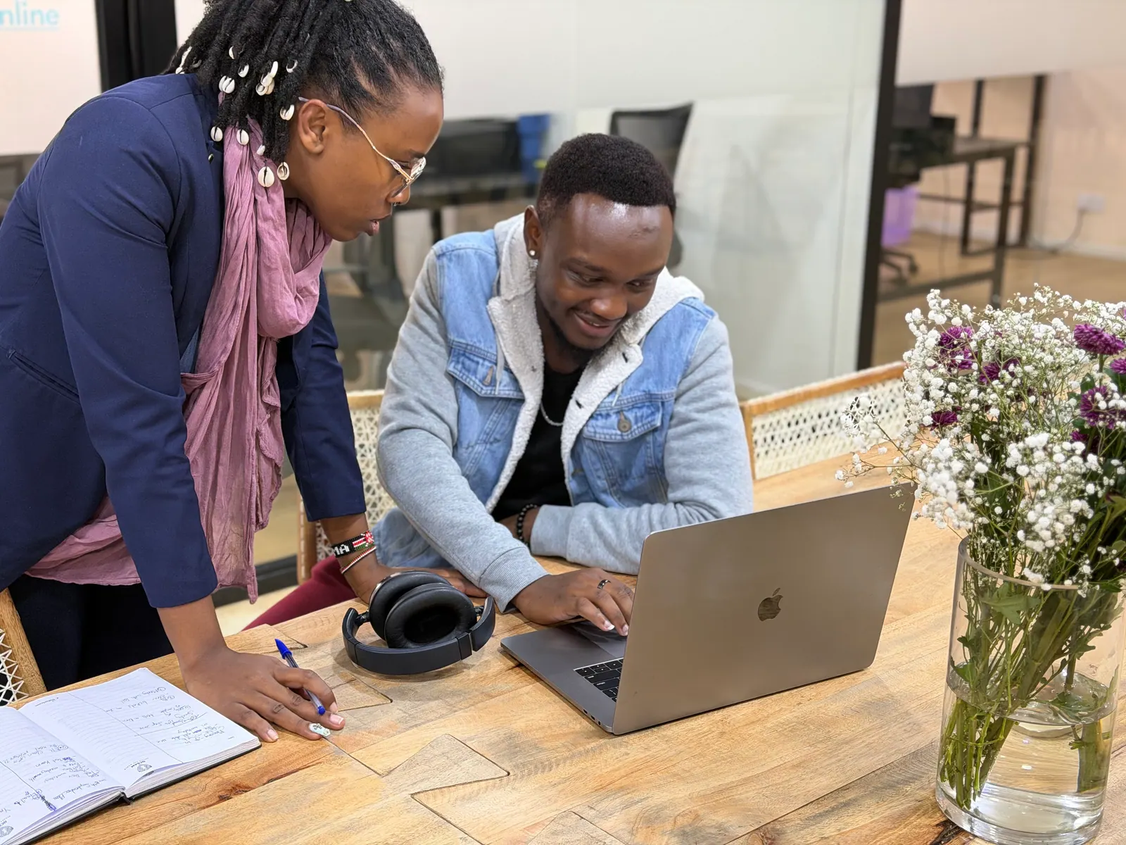 Two Data XL colleagues working together over a laptop in the Nairobi office